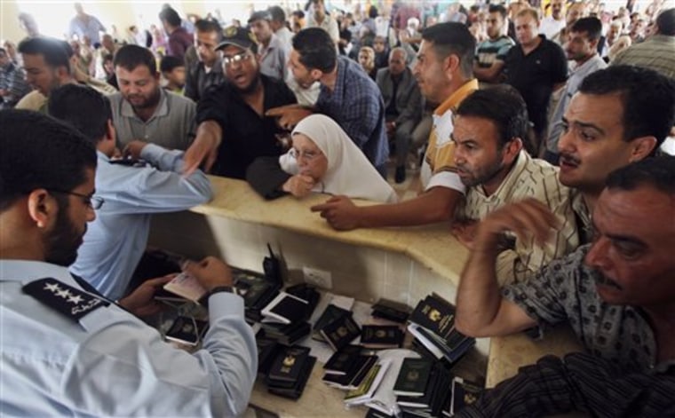Palestinians wait for Hamas police officers to check their passports as they wait to cross into Egypt at the Rafah border crossing in Gaza on Tuesday.